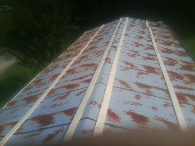 Rusted metal roof panels with new wood purlins before replacement — Storm Damage Roof Repair in Newcomerstown by Roofing Brothers