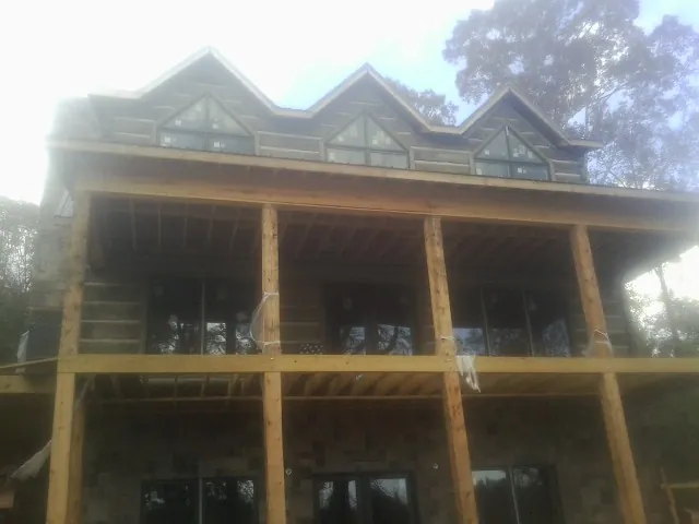 Dormers and porch framing on a large log home under construction — Roof Coating work by our crew in Newcomerstown