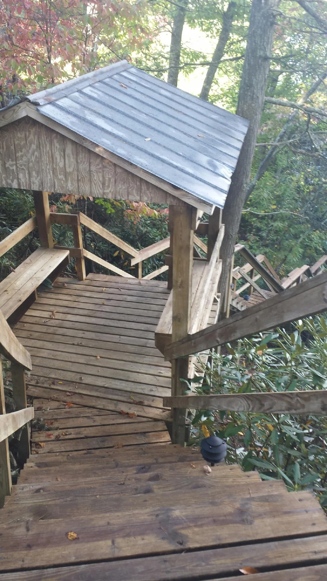 Metal roofed shelter over wooden steps on a wooded walkway — Skylight Repair & Installation work by our crew in Newcomerstown