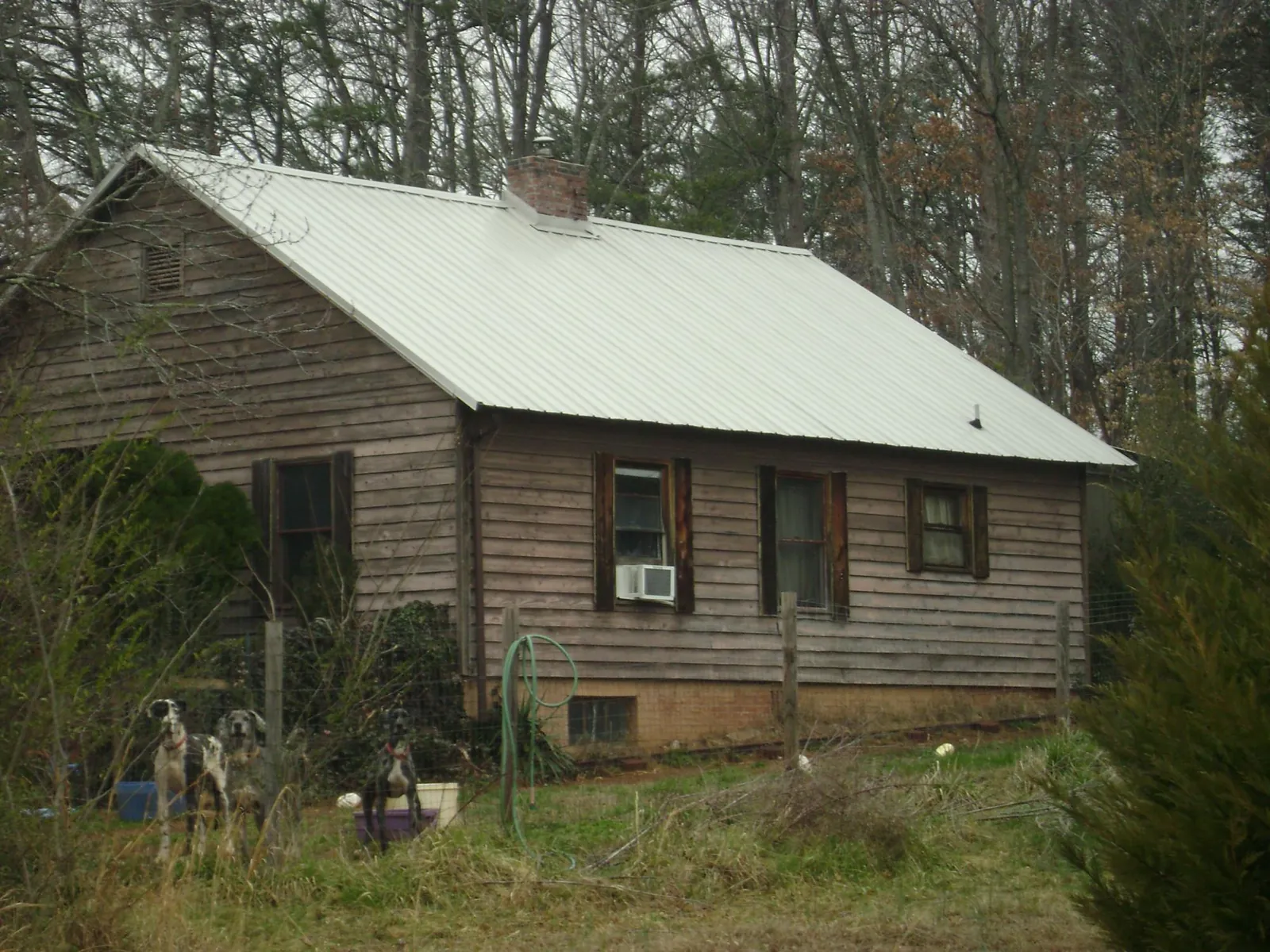 White metal roof on an old wood sided farmhouse, from a Metal Roof Installation job in Newcomerstown